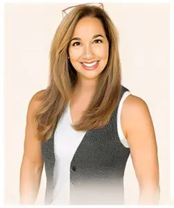 Smiling woman in white shirt and vest.